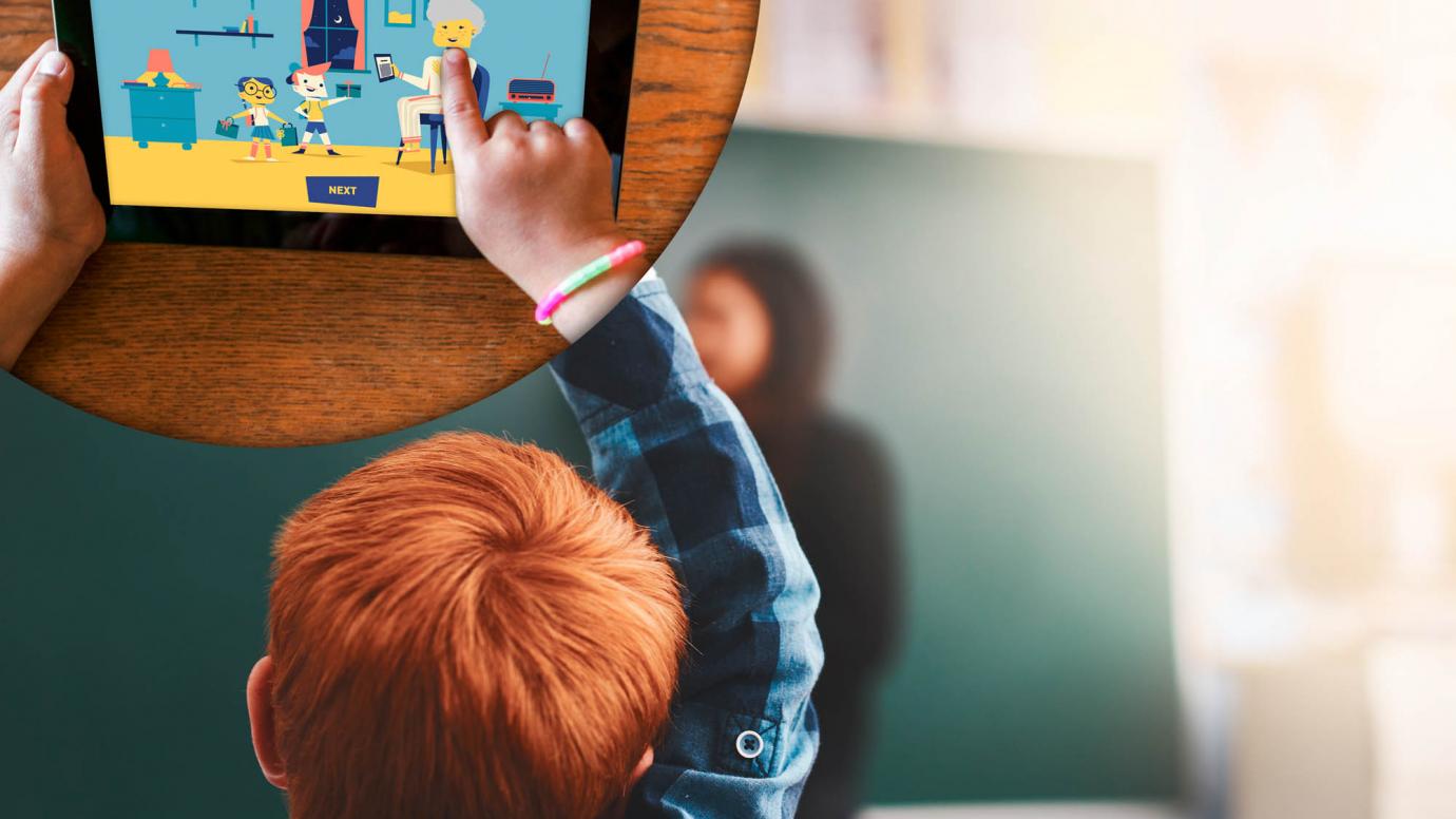 Į planšetinio kompiuterio ekraną žiūrintis vaikas