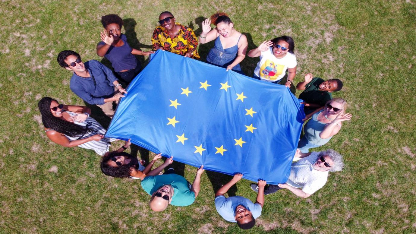 A group of young people in a park holding an EU flag
