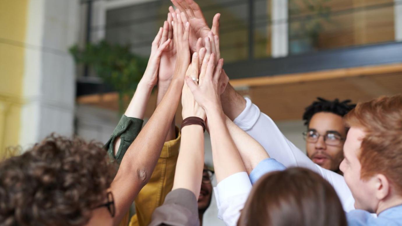 A group of people with their hands touching in the air