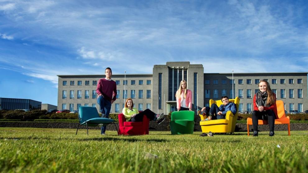 Students sitting on colourful chairs outside the university of Iceland